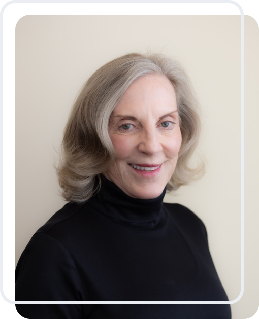 Portrait of a smiling elderly woman with gray hair in a black turtleneck.